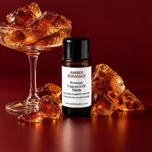 Amber Romance fragrance oil bottle with a glass pedestal dish filled with amber-coloured chunks and scattered pieces.