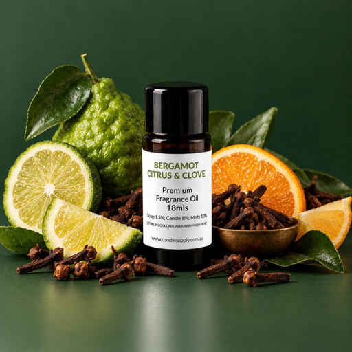Bergamot Citrus & Clove fragrance oil bottle with green citrus fruit, orange slices and whole cloves in a wooden bowl.