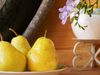 two pears on a plate with flower pot in background