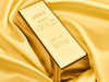 Gold bar with '999.9 Fine Gold' text on a gold fabric background