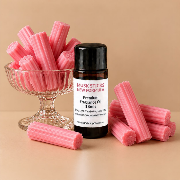 Musk Sticks New Formula fragrance oil bottle with pink musk stick sweets in a glass dessert dish and on the surface.