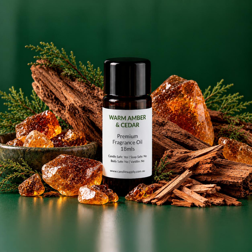 Warm Amber & Cedar fragrance oil bottle with amber-coloured chunks, a bowl of resin pieces, rough wood and evergreen sprigs.