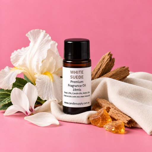 White Suede fragrance oil bottle with white flowers, draped cream fabric, pieces of wood and amber-coloured chunks.